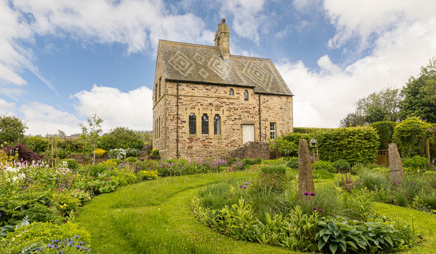 side view of the church house with lush manicured gardens